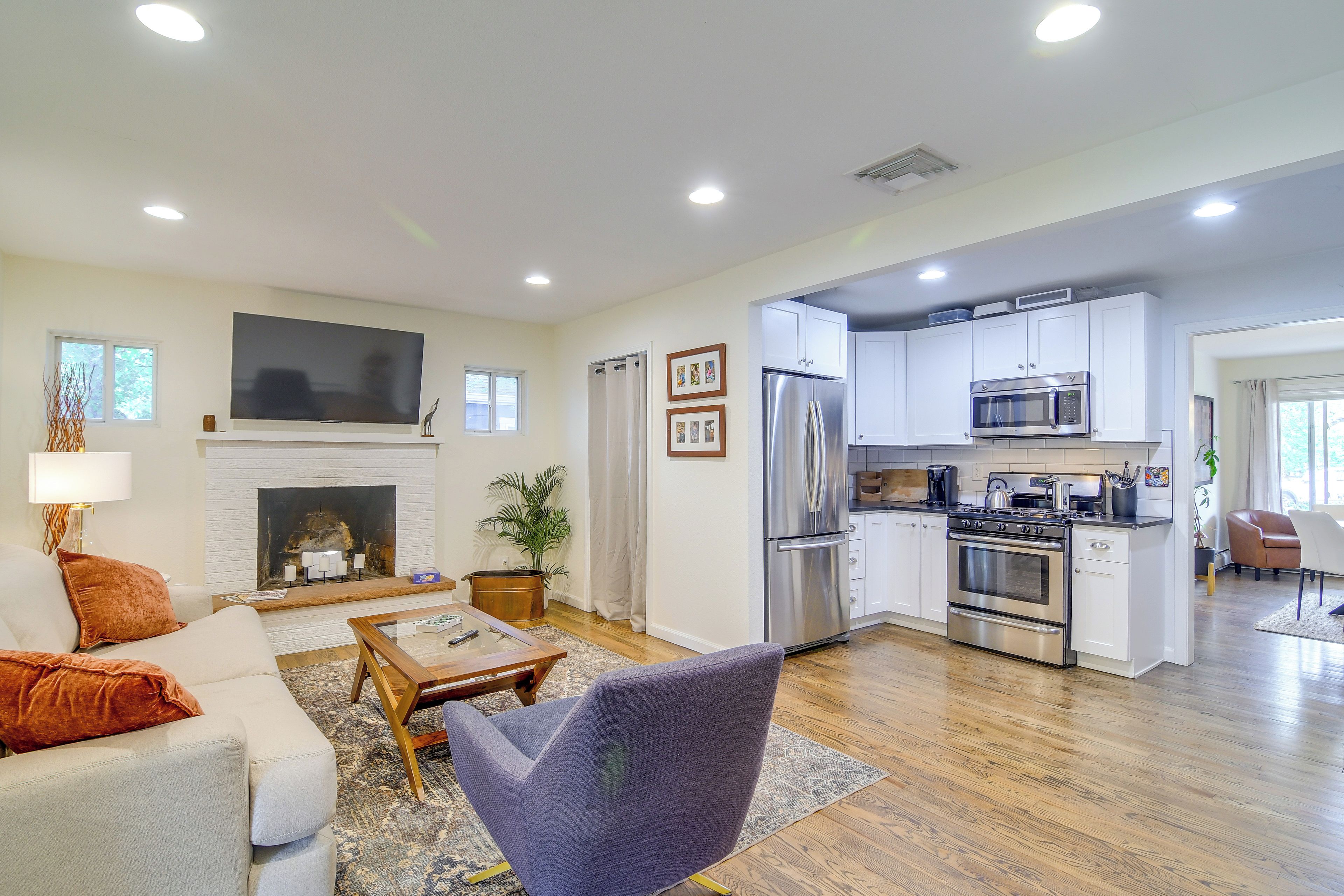 A spacious living area with a fireplace, a television, and a kitchen with modern appliances.