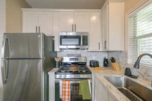 A kitchen with a stainless steel refrigerator, a microwave, a stove, and a sink. - Walk to Texas A&m! Quiet Home w/ Fenced Yard (College Station)