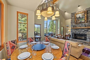 A dining room with a round table set for six, surrounded by chairs with patterned cushions. - Moonlit Hearth & Hickory | Ski-In/Out + Hot Tub (Big Sky)