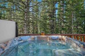 A hot tub with a view of a forested area. - Moonlit Hearth & Hickory | Ski-In/Out + Hot Tub (Big Sky)