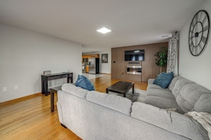 A modern living room with a sofa, coffee table, and a television mounted on the wall.