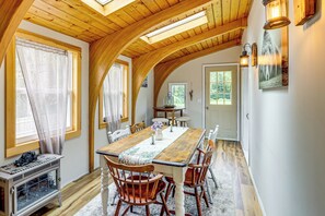 A dining area with a long wooden table, chairs, and a fireplace. - 1/2 Mi to Marina! Lake George Group Getaway (Diamond Point)