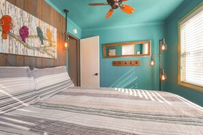 A bedroom with a bed, a ceiling fan, a wall-mounted mirror, and a window with blinds. - Dock + Year-round Fishing! Lakefront Michigan Home (Newaygo)