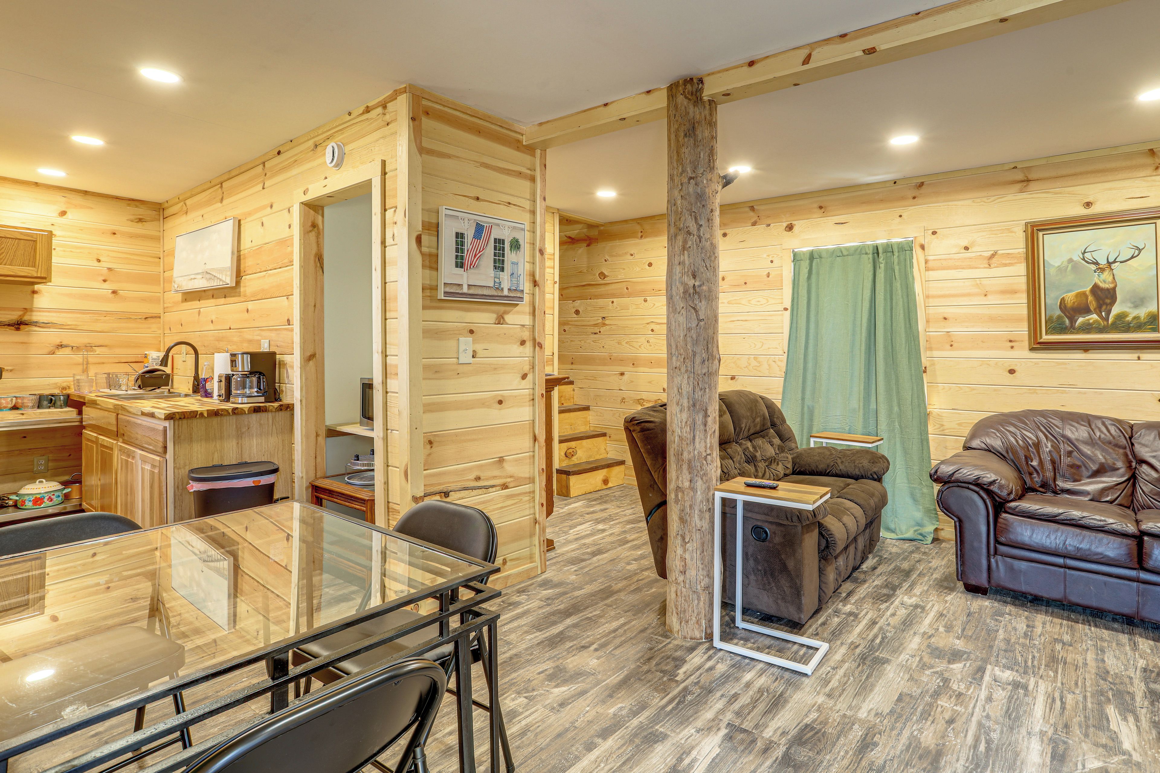 A wooden interior with a dining area, kitchen, and seating space.