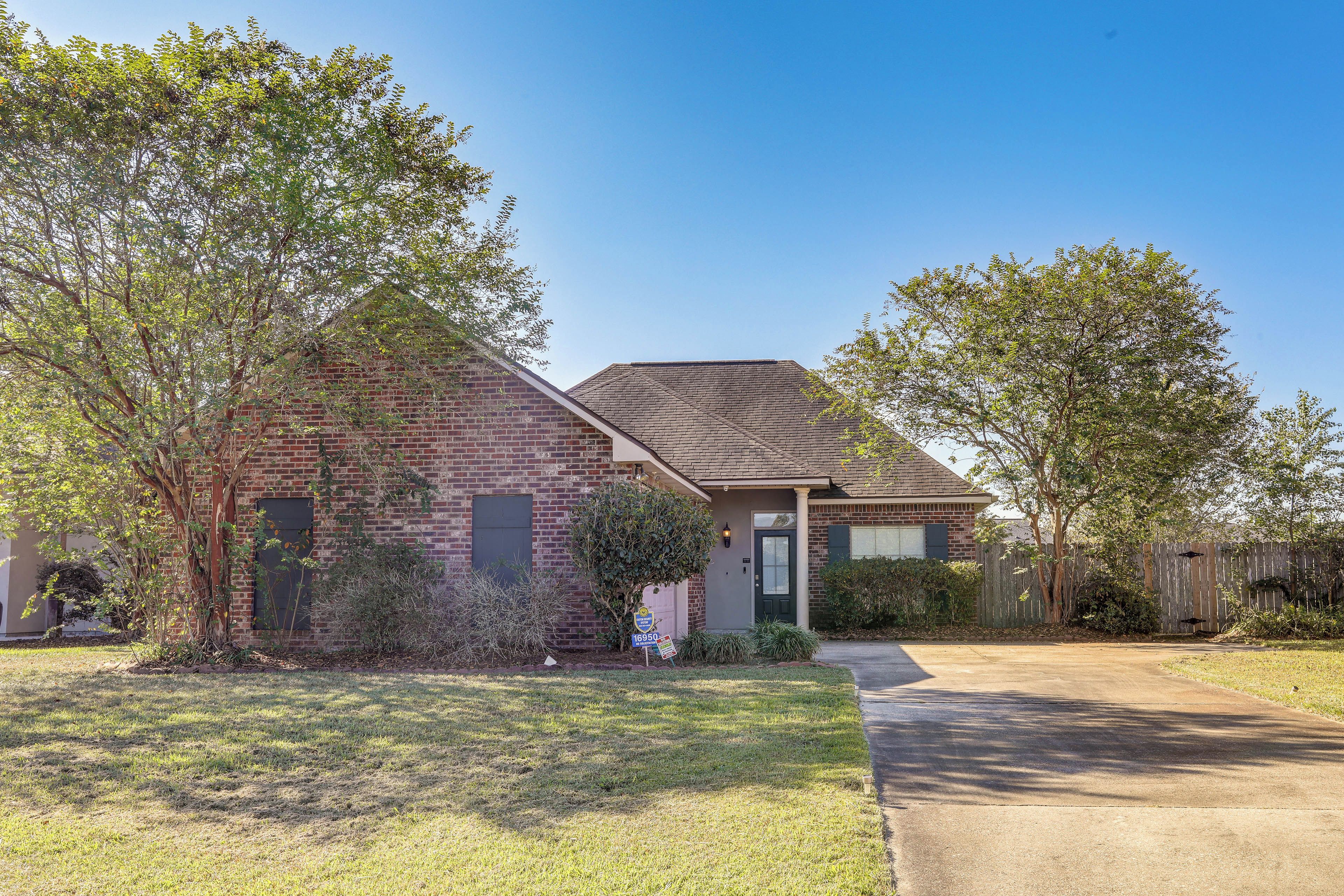 A two-story house with a brick facade, a front porch, and a well-maintained lawn.