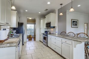 A kitchen with white cabinets, granite countertops, a built-in oven, and pendant lighting. - Waterfront Home Near Nature Trails & Lsu! (Greenwell Springs)
