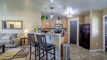 A modern kitchen with a central island, stainless steel appliances, and wooden cabinets.