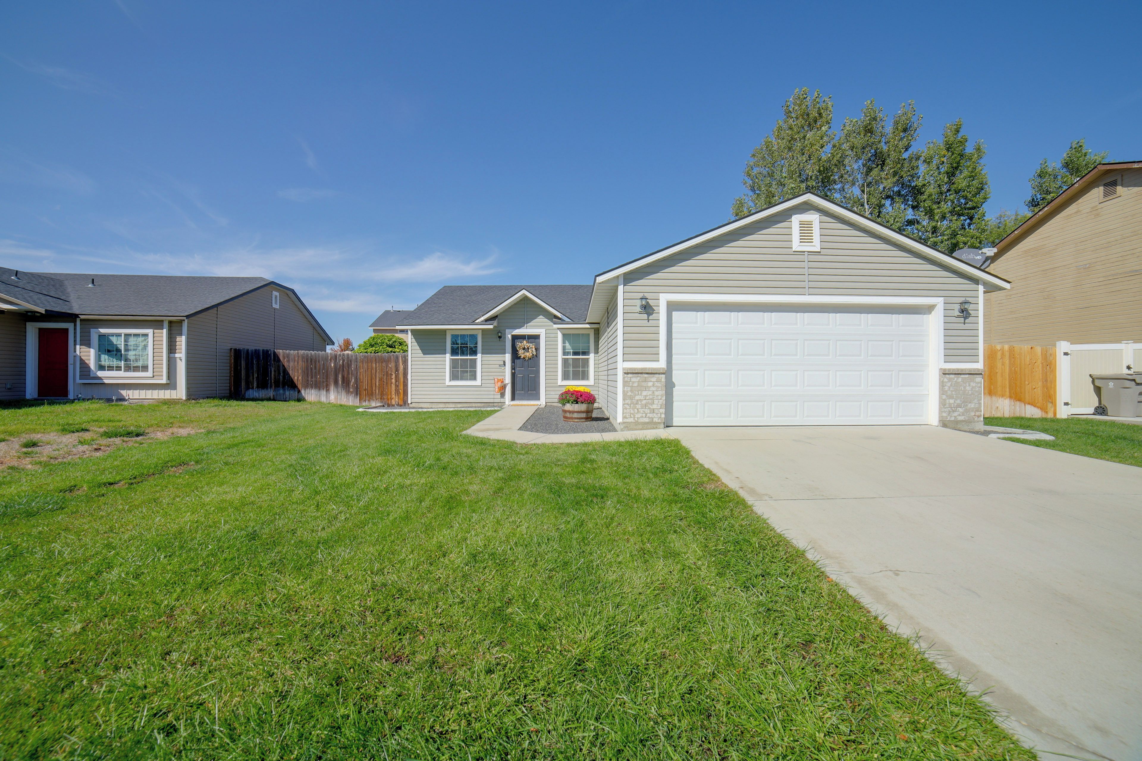 A residential area with houses, a well-maintained lawn, and a clear sky.
