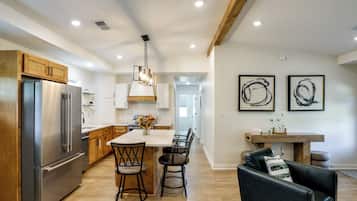 A modern kitchen with a central island, stainless steel appliances, and wooden cabinetry.
