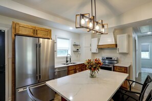 A modern kitchen with stainless steel appliances, wooden cabinets, and a marble countertop. - Quiet & Cozy Retreat Near Oxford & Holly Springs (Waterford)