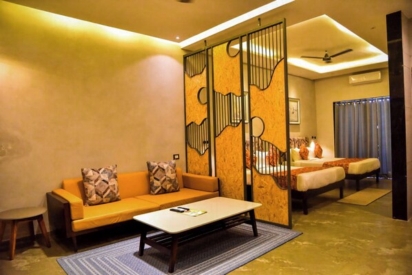 A modern hotel room with a sofa, a coffee table, a bed, and a partition with a unique design. - EcoTown Resort (Jaipur)