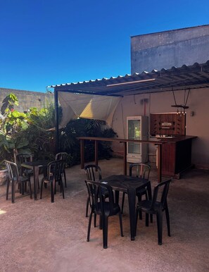 An outdoor patio with a table and chairs, a bar area, and a covered seating area.