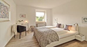 A bedroom with a bed, bedside tables, a desk, and a window. - Your temporary home in beautiful Piesport on the Moselle (Piesport)