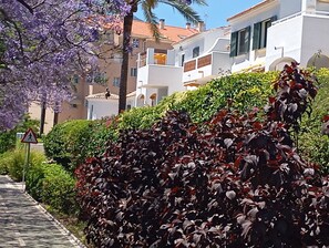 A residential area with a pedestrian crossing sign, a pathway, and a row of white buildings with balconies. - Pueblo del Parque Pool View
Apartment | South-Facing Terrace | Walk to Beach (Benalmádena)