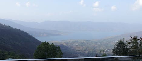 A terrace with a view of a valley and a body of water.