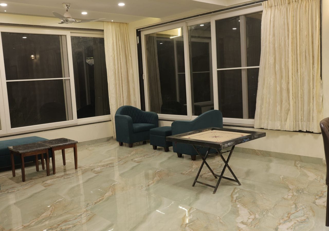 A room with a large window, a ceiling fan, and a table with a marble floor.