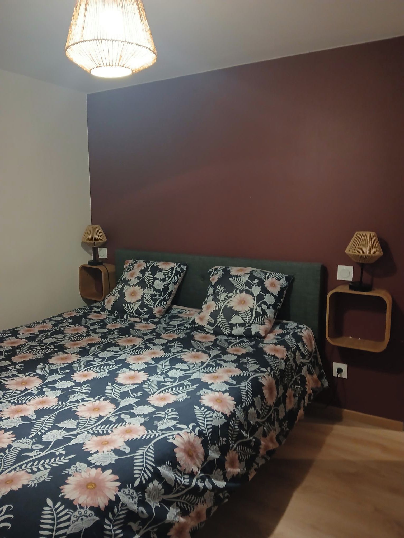 Un dormitorio con una cama, dos lámparas de pared y una lámpara de techo.
