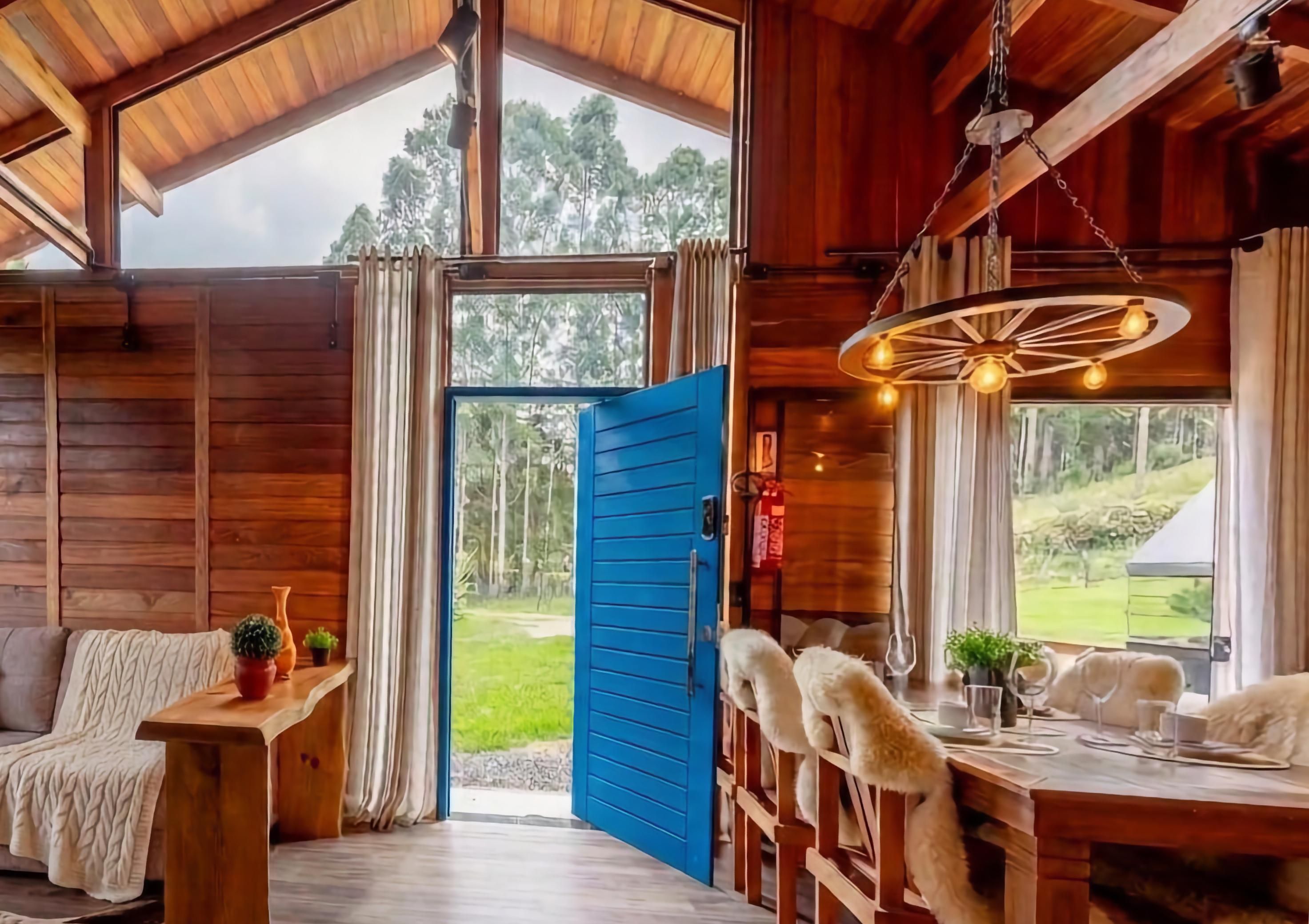 L’intérieur d’un chalet en bois comprend un coin repas, un canapé et offre une vue sur l’extérieur.