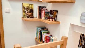 Una habitación con estantes de madera llenos de libros y una pequeña planta.