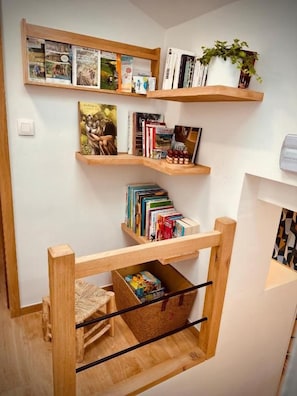 Une pièce avec des étagères en bois remplies de livres et une petite plante.