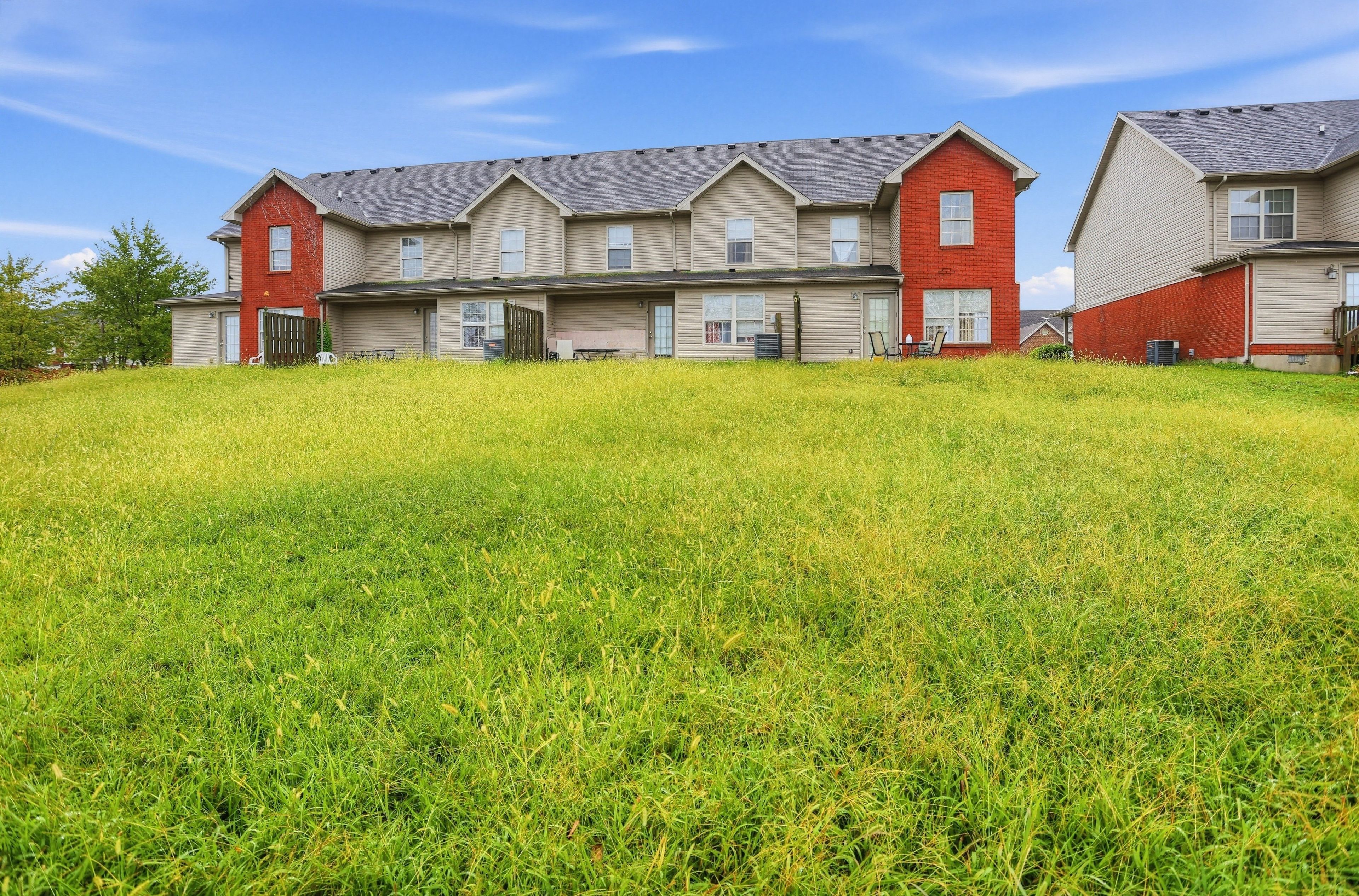 A row of two-story houses with a grassy front yard.