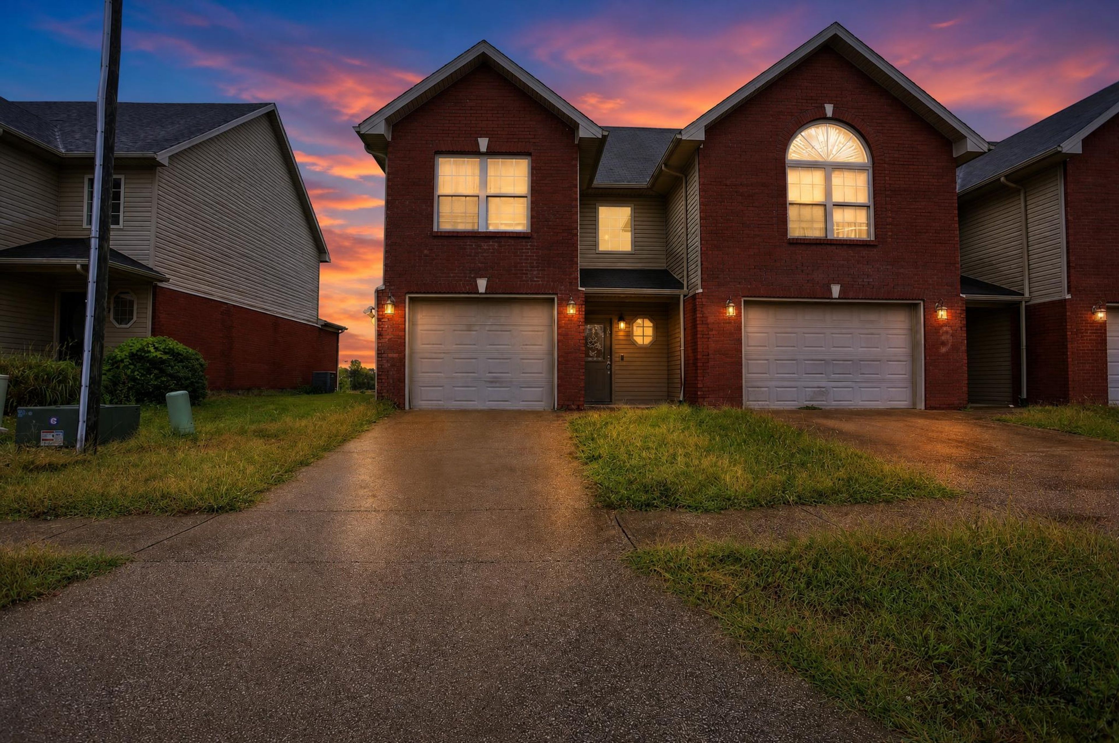 A two-story residential building with a driveway leading to a garage.