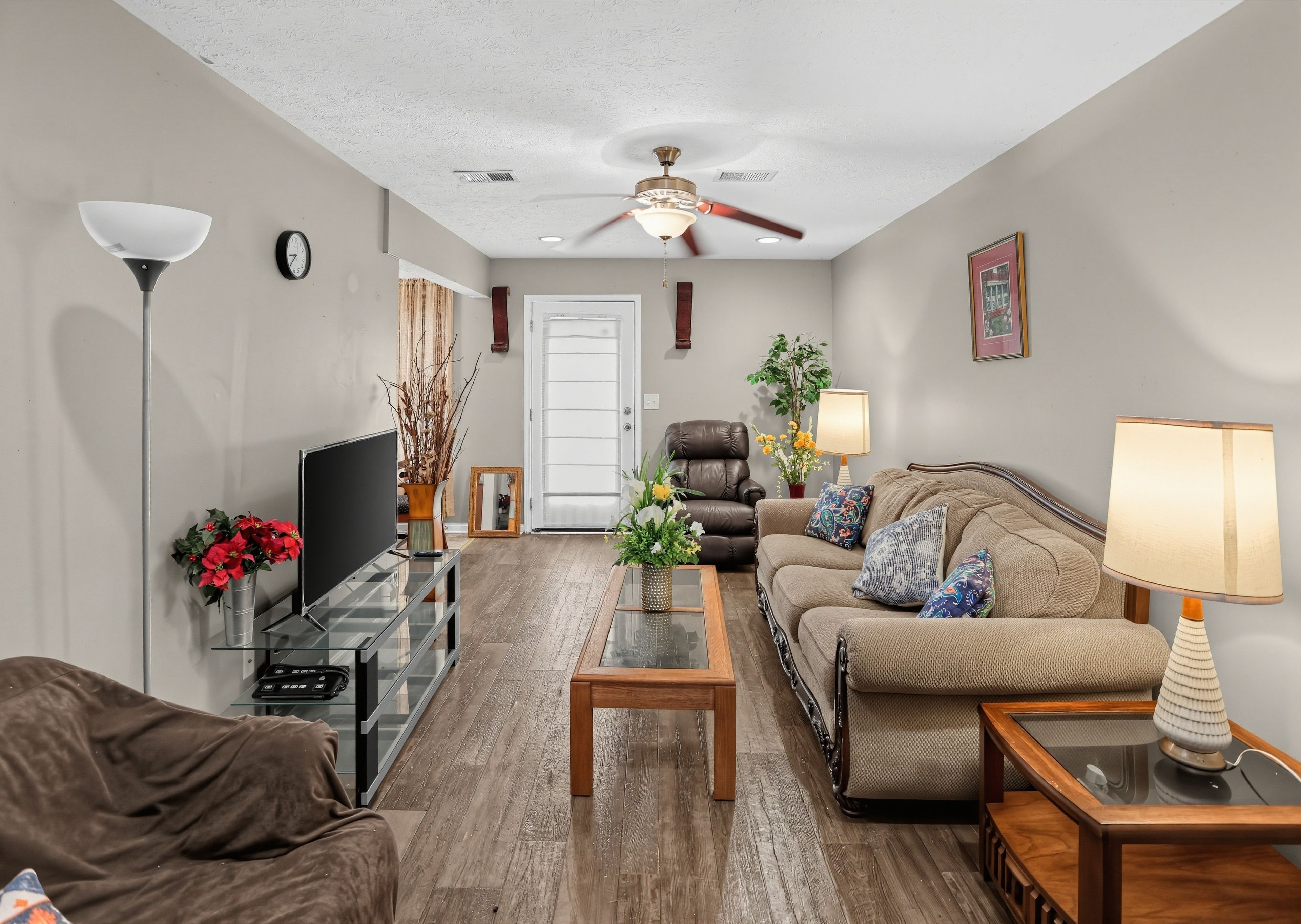 A living room with a sofa, coffee table, TV, and decorative items.