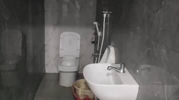 Een badkamer met toilet, wastafel en douche.