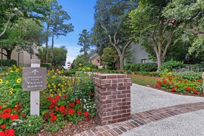 A sign for Harbour Town Yacht Basin with a brick pillar and flower beds. - One bedroom oasis in the heart of sea pines with harbour and lighthouse views (Hilton Head Island)