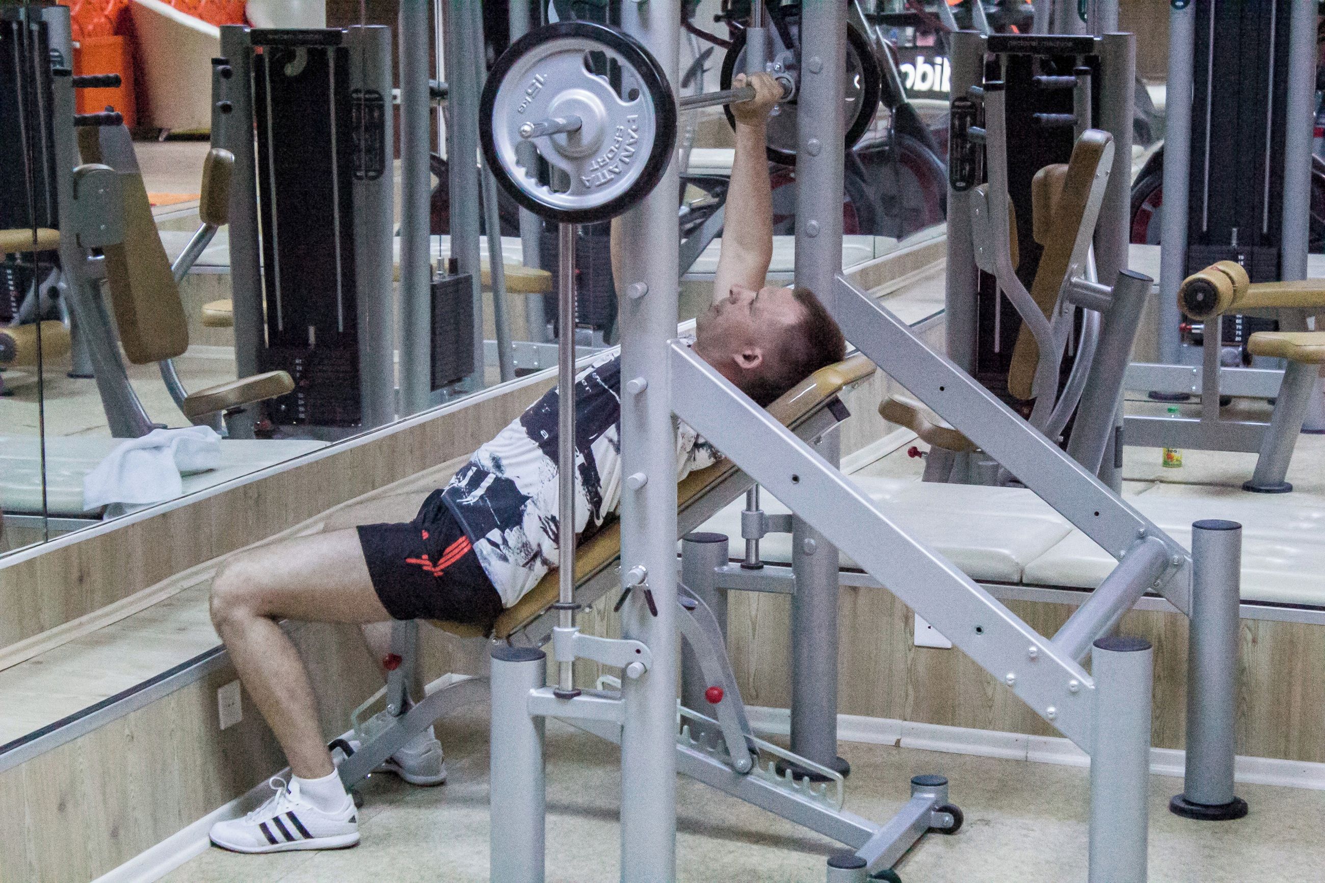 Un gimnasio con equipo de ejercicio, que incluye una prensa de banca y una estructura para sentadillas.