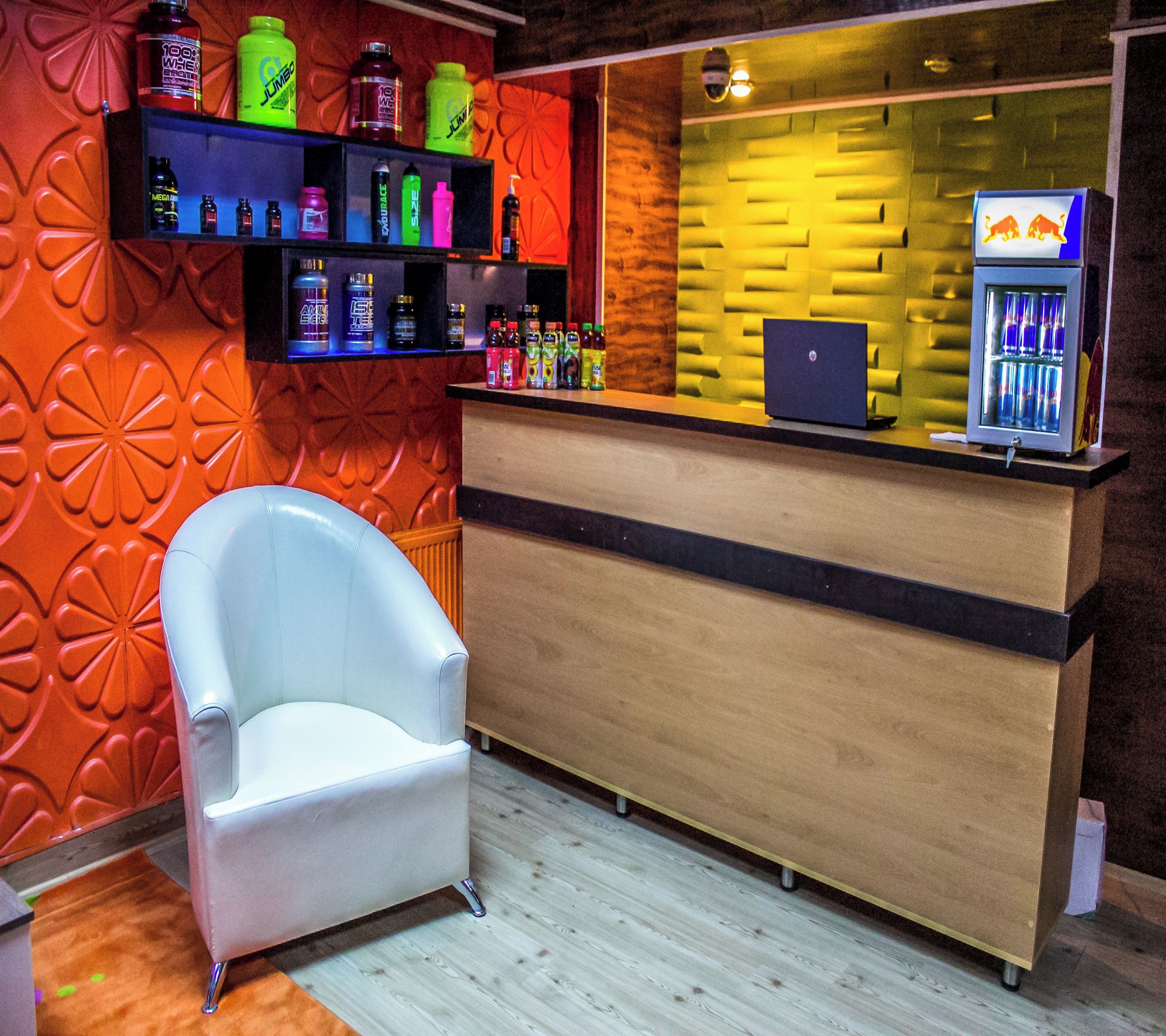Un área de recepción con un escritorio de madera, un sillón blanco y estantes con diversos productos.