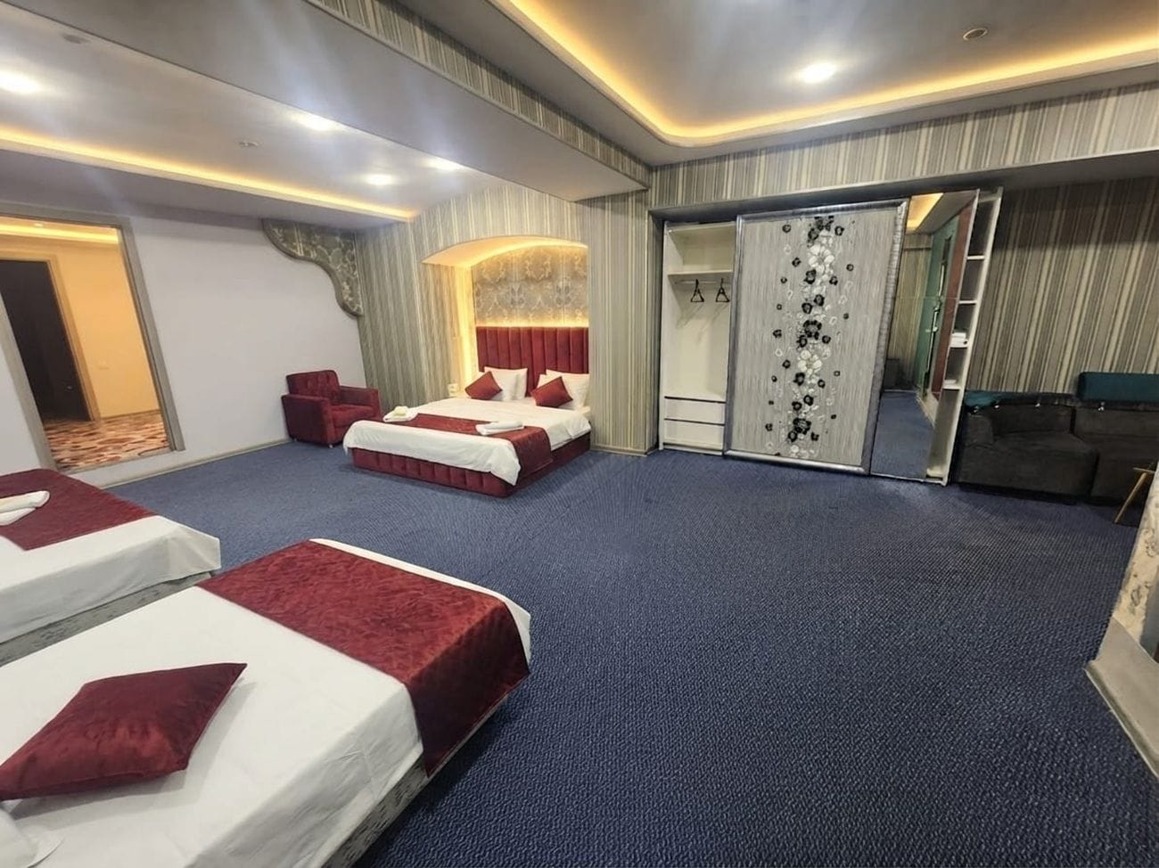 Een hotelkamer met twee bedden, een zithoek, een kledingkast en een spiegel.