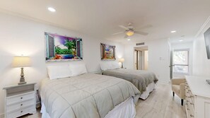 A bedroom with two beds, a ceiling fan, and artwork on the walls. - 89 The Moorings: 2  BR, 3  BA Villa in Hilton Head, Sleeps 6 (Hilton Head)