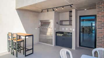 Una cocina moderna con horno empotrado y comedor con mesa y sillas.