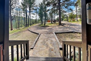 A paved pathway leading to a building surrounded by trees. - Gonzo Chalet | Spacious Deck + Mountain Views (Ruidoso)