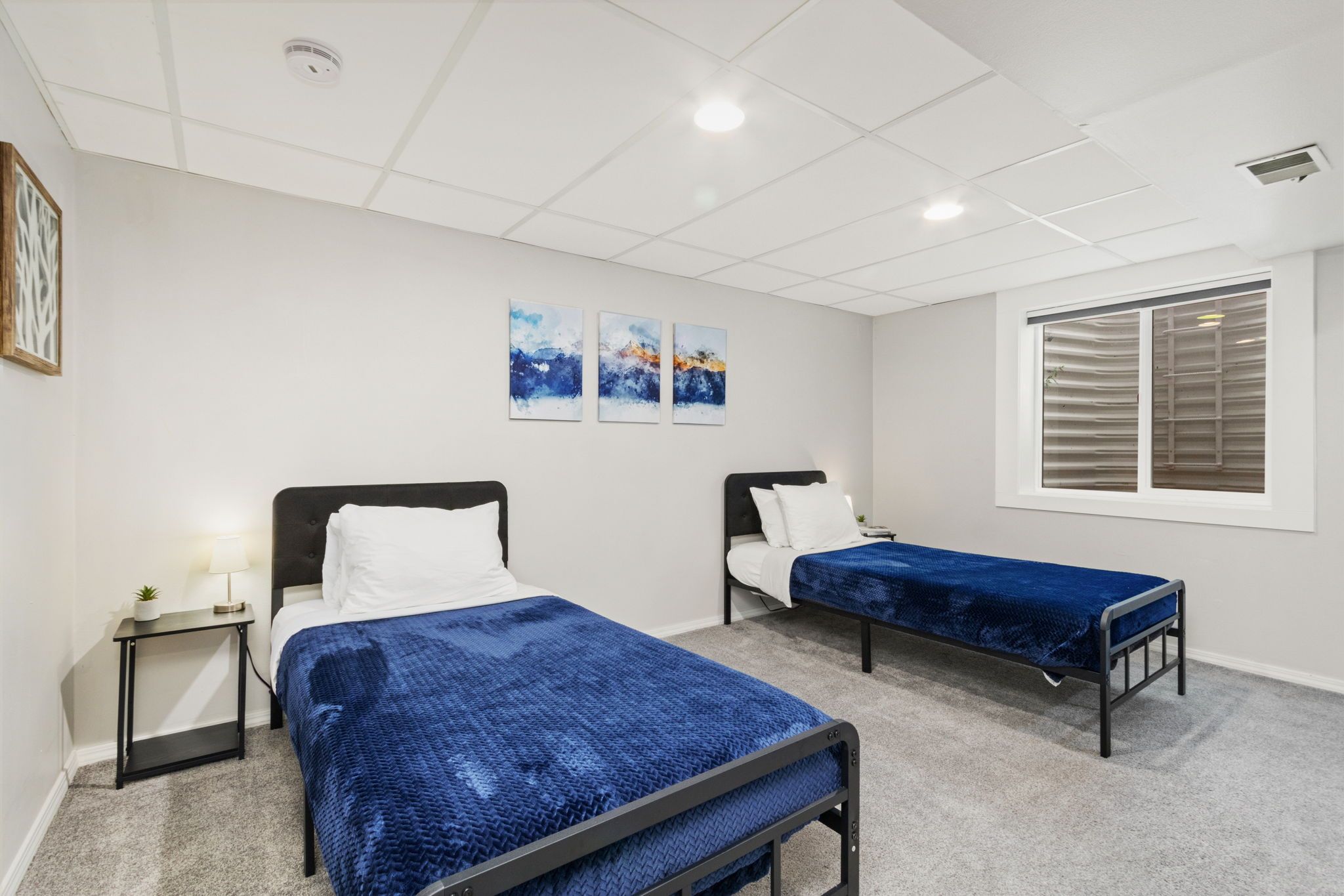 Ein Hotelzimmer mit zwei Betten, einem Fenster und Bildern an der Wand.
