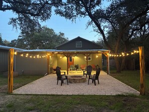 A covered patio area with outdoor seating and string lights. - Cozy Gruene Cottage - a short distance to Gruene and the Guadalupe River (New Braunfels)