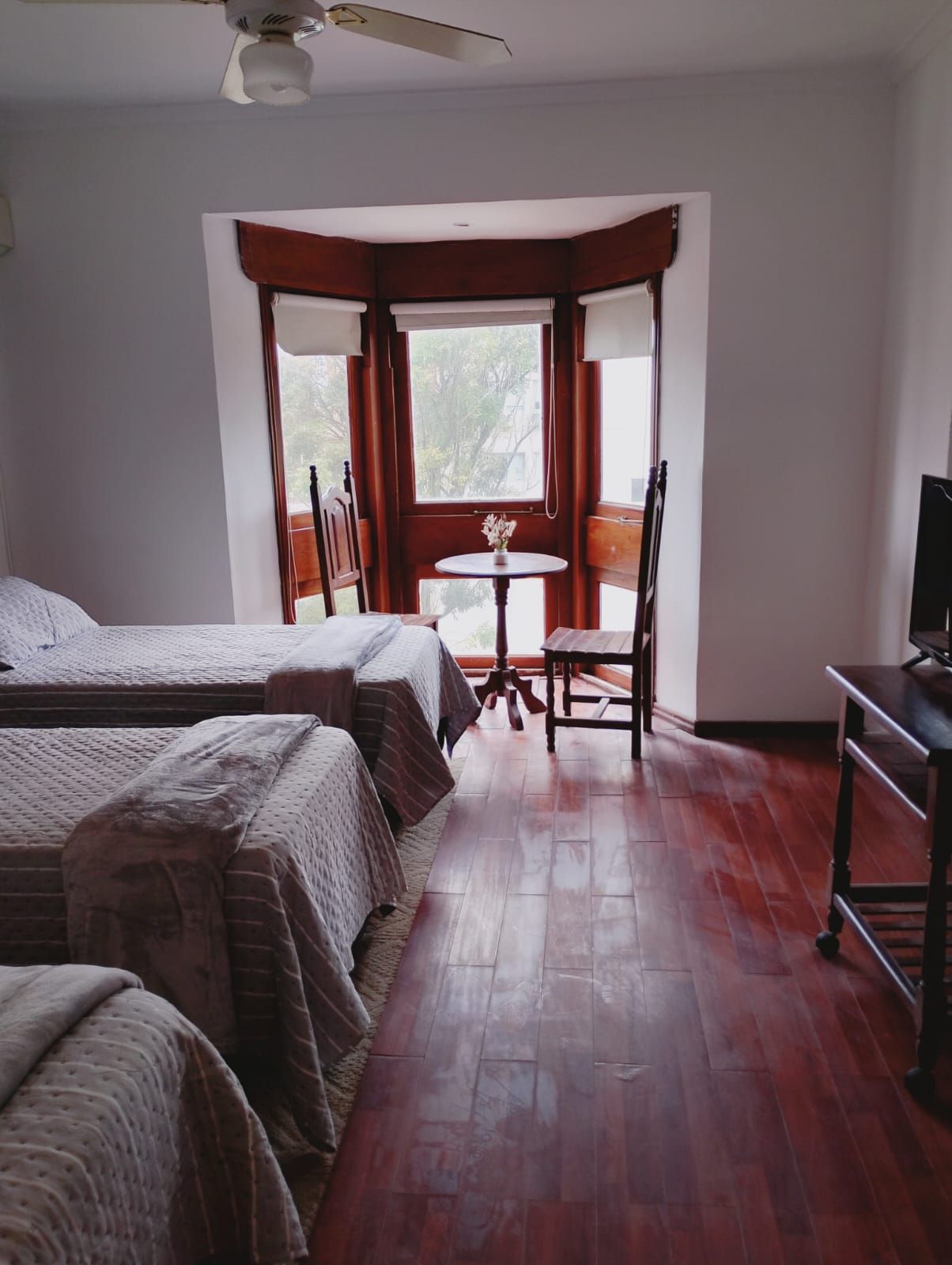 Une chambre avec deux lits, une petite table et une chaise, ainsi qu’un téléviseur.