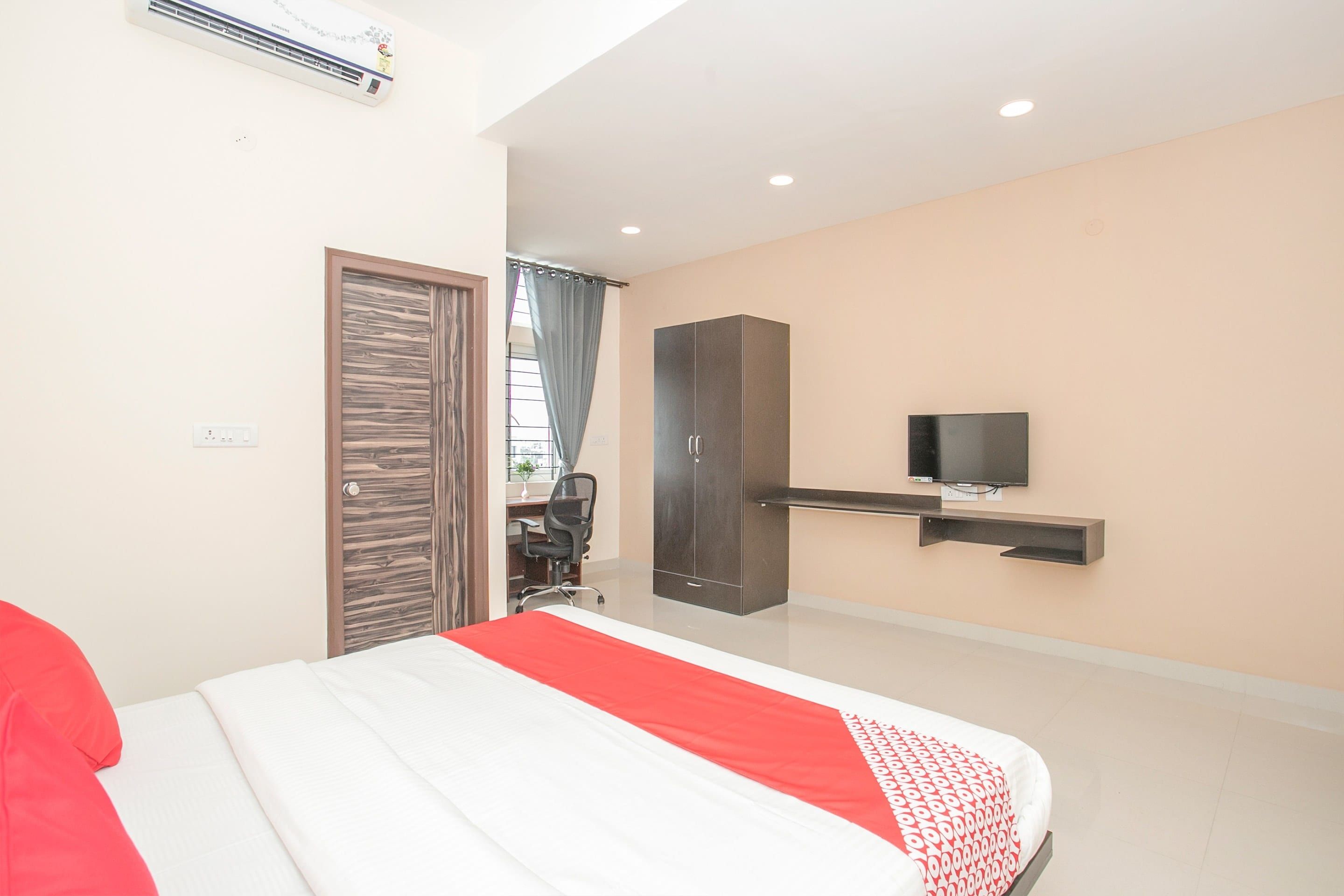 Une chambre à coucher moderne, équipée d’un lit, d’une armoire, d’un bureau et d’un téléviseur.