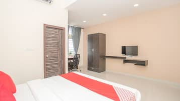Une chambre à coucher moderne, équipée d’un lit, d’une armoire, d’un bureau et d’un téléviseur.