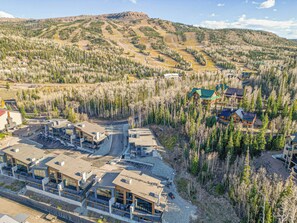 A modern resort with multiple buildings, a ski slope in the background, and a mountainous landscape. - Ski-In/Out Luxury | Private Hot Tub + Sauna (Brian Head)