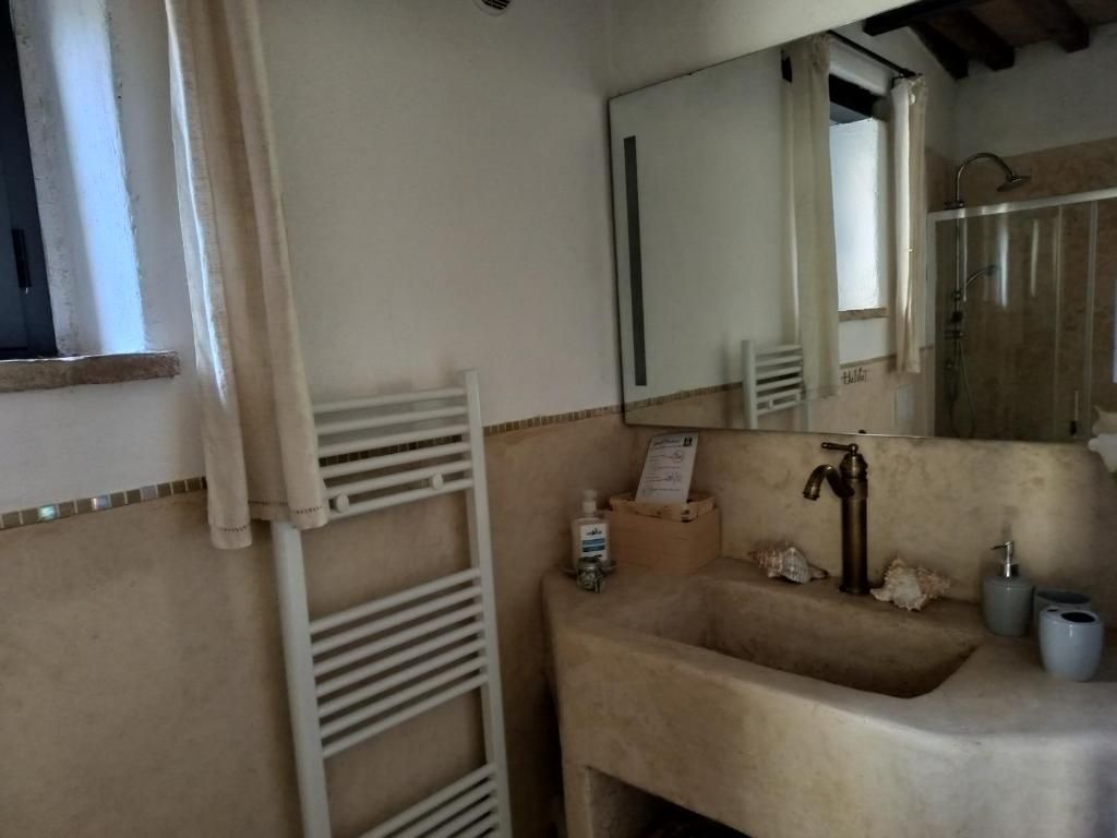 Un baño con lavamanos, espejo, toallero y zona de ducha.