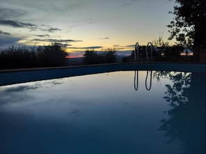 A swimming pool with a clear view of the sky and surrounding trees. - Vecchio Casale Quercetino  (Montenero)