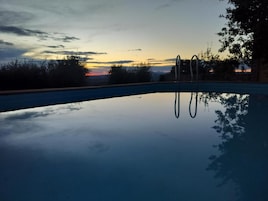 Una piscina con vista despejada al cielo y árboles circundantes.