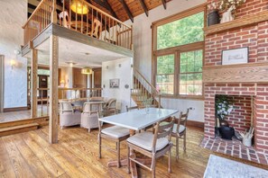 A spacious dining area with a high ceiling and a fireplace.