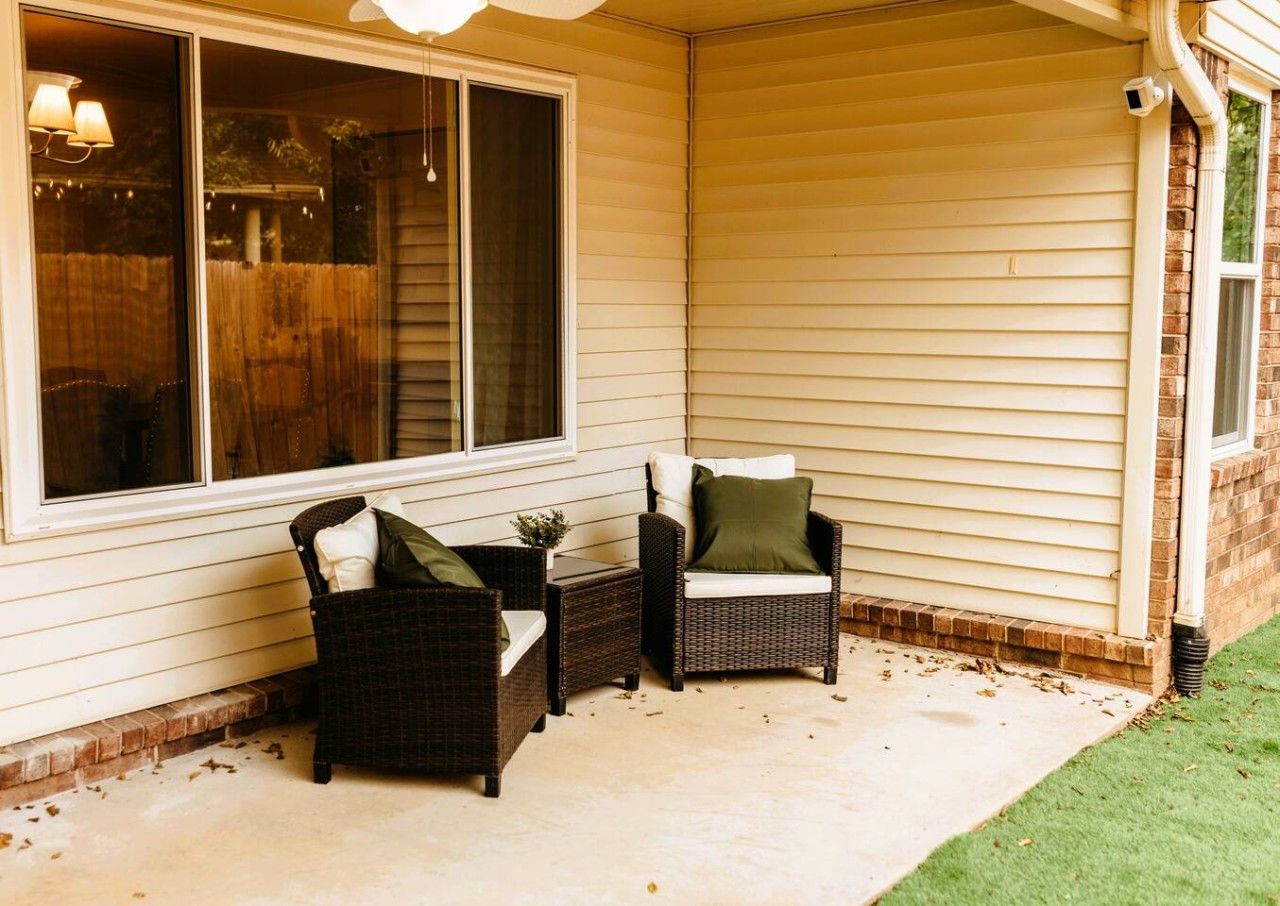 A covered porch with wicker furniture and a window.
