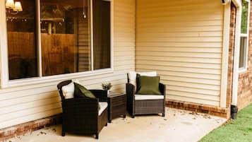 A covered porch with wicker furniture and a window.