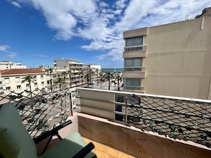 Ein Balkon mit Blick auf eine Küstenstadt, einschließlich Gebäude und Palmen.