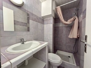 Ein Badezimmer mit Waschbecken, Toilette und Duschbereich.