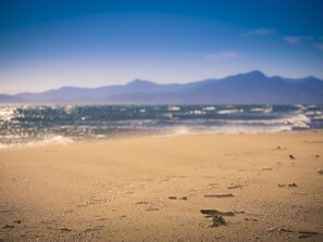 Ein Strand mit einer Bergkette im Hintergrund.